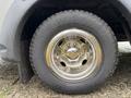 A close-up of a polished chrome wheel with lug nuts and a Goodyear tire on a 2020 Chevrolet Express van