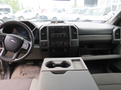 Interior view of a 2017 Ford F-250 Super Duty with a black steering wheel and dashboard featuring climate controls and a center console with cup holders
