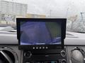 A dashboard screen displaying a rearview camera image showing a clear view of the ground and surrounding area behind a 2011 Ford F-650