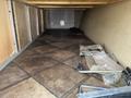 The interior of a 2013 Outdoor Wind River showcasing tiled flooring and various tools and materials scattered on the ground