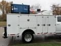 2024 RAM 5500 service truck with a white utility body featuring multiple compartments and mounted equipment on the roof