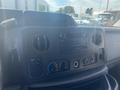 Dashboard of a 2009 Ford Econoline featuring climate control buttons a radio and a digital display