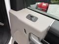 Interior panel of a 2021 Ford F600 featuring a window control switch and door handle.
