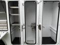 The image shows the interior of a white food truck with empty shelving and compartments designed for storage and food preparation