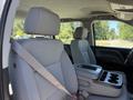 Interior of a 2016 GMC Sierra 1500 showing two front seats with seatbelt and a center console featuring cup holders and storage compartment