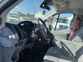 Interior view of a 2016 Ford Transit showing the driver's seat steering wheel and dashboard with controls and storage compartments