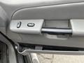 Interior door handle and control panel of a 2004 Ford Explorer Sport Trac featuring buttons for window and door lock functions