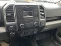 Interior dashboard of a 2016 Ford F-150 featuring a central audio display multiple control buttons and dials