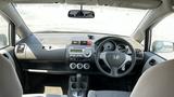 Interior view of a 2006 Honda Fit showcasing the dashboard steering wheel and control panel with air conditioning vents and audio system