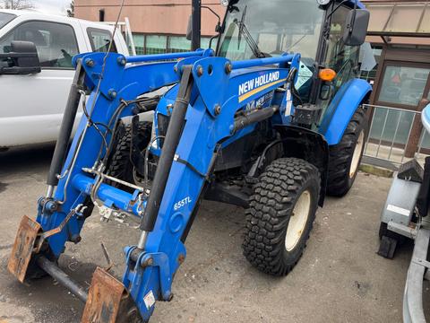 A 2016 New Holland T475 tractor in blue with a front loader attachment and large tires