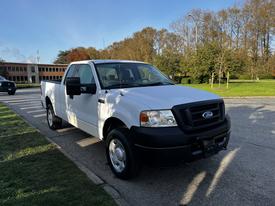 A white 2008 Ford F-150 XL pickup truck with a black grille and a single cab parked on the side of a road