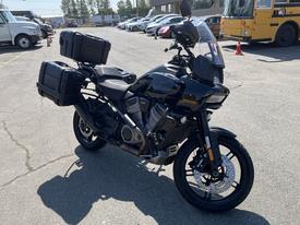 A black 2021 Harley-Davidson RA1250 S motorcycle with side panniers and a tall windscreen parked on a paved surface