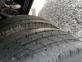 Close-up of two worn tires from a 2004 Toyota Toyoace showcasing significant tread wear and a rough surface