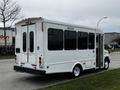 A 2016 Ford Econoline shuttle bus in white with large windows and a side door accessible for passengers with disabilities