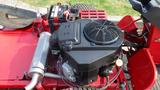 Top view of a 2014 Ferris Mower ISX 800 featuring an engine with a black cover a fuel line and a battery connected to the mower