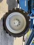 Close-up of a large rubber tire mounted on a wheel with a central hub showing bolts on a 2012 Genie Z 45/25 lift