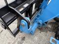 Close-up of a blue Genie GTH-5519 telehandler attachment showing the connection points and hydraulic components