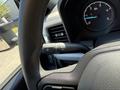Close-up of the steering wheel and control stalks of a 2023 Ford F-550 showing turn signal and windshield wiper controls