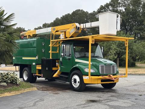 A green 2015 Freightliner M2 106 bucket truck with a yellow lift system on top and a green utility box on the side