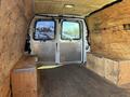 Interior view of a 2012 Chevrolet Express cargo van featuring wooden walls and two wooden benches on either side of the cargo area
