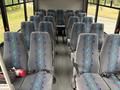 Interior view of a 2020 Chevrolet Express bus featuring rows of grey fabric seats with blue and green wave patterns