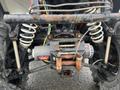 A 2017 Polaris Scrambler with a visible winch and suspension components showcasing worn and rusted parts on the frame and tires