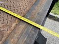 A measuring tape extended across a rusty metal truck bed of a 2014 International TerraStar