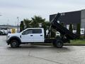 A white 2017 Ford F-450 Super Duty with the dump bed elevated, displaying its large chassis and wheels, designed for heavy-duty hauling and construction tasks