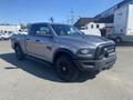 A 2021 RAM 1500 pickup truck in gray with black accents and wheels parked on a paved surface