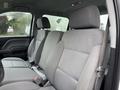 Interior of a 2015 GMC Sierra 1500 showing two front seats in gray fabric with adjustable headrests and seat belts