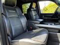 Interior view of a 2022 RAM 3500 truck featuring black leather seats with stitching and a spacious center console