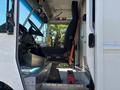 Interior of a 2019 Freightliner MT45 showing the driver's seat positioned next to the steering wheel and dashboard with visible controls and a step platform