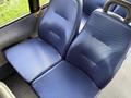 A pair of blue upholstered seats in a Chevrolet Express van with a textured pattern on the fabric