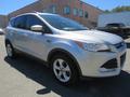 A silver 2015 Ford Escape parked with a sporty design featuring a sleek front grille and modern alloy wheels