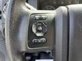 Close-up of the steering wheel control buttons in a 2016 Ford F-550 featuring options for setup info and reset