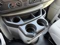 Interior cup holder console of a 2023 Ford E-450 with two large cup holders and control panel above