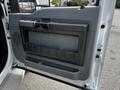 The interior door panel of a 2016 Ford F-550 featuring a gray plastic surface with a handle and storage compartment