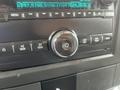 A close-up view of the dashboard controls of a 2016 Chevrolet Express featuring a knob for power and several buttons for radio and media functions