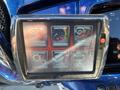 A digital display mounted on a motorcycle featuring six icons for program vehicle, data log, vehicle tools, settings, device info, and dealer options