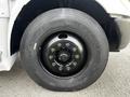 Close-up of a black wheel with multiple lug nuts on a 2013 International 4200 showcasing a heavy-duty tire designed for commercial use