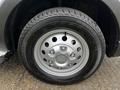 A close-up of a silver wheel from a 2023 Ford Transit featuring a five-spoke design and a textured tire tread