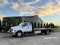 A 2006 Ford F-650 truck with a flatbed design parked in a lot