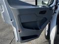 The interior door panel of a 2017 Ford Transit featuring a gray design with a handle and storage compartment