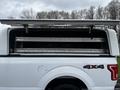 A white 2017 Ford F-150 with an open truck bed cover revealing storage compartments inside