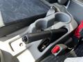 A close-up view of the gear shift lever and cup holders in the cab of a 2020 Hino 155 truck