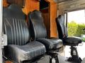 Interior view of a Morgan Olson Workhorse with three black leather driver seats arranged in a row