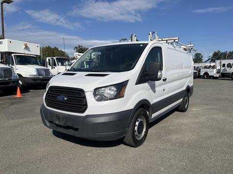 A white 2016 Ford Transit van with a black grille and gray bumpers parked at an angle showcasing its front and side features