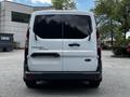 A white 2016 Ford Transit Connect van with tinted rear windows parked and facing the camera