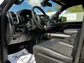 Interior of a 2019 RAM 1500 with a black steering wheel and leather seats featuring a center console and dashboard controls