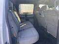 Interior view of a 2017 Ford F-150 showing the rear passenger seating area with gray fabric upholstery and ample legroom